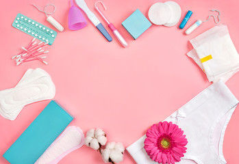 Heart symbol. Sanitary napkins and other hygiene accessories on pink background. Concept of critical days, menstruation