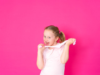 girl is playing with yellow slime in front of pink background