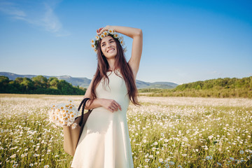 Beautiful girl in daisy field. Summer sunset