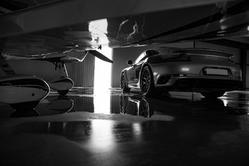 propeller plane with sport car in a hangar at an airfield. rich life