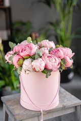 Pink peonies on the old grey table. Beautiful peony flower for catalog or online store. Floral shop...
