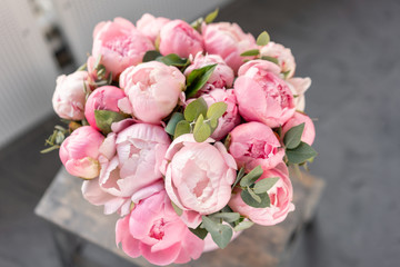 Pink peonies on the old grey table. Beautiful peony flower for catalog or online store. Floral shop concept . Beautiful fresh cut bouquet. Flowers delivery