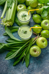 Detox program. Smoothie green apples, celery, ramson and limes on a concrete background.