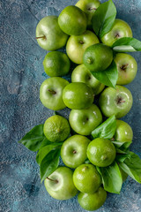 Apples and limes on a dark blue concrete background. Top view. Vertical shot