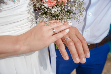 Newlywed couple holding hands and displaying wedding rings