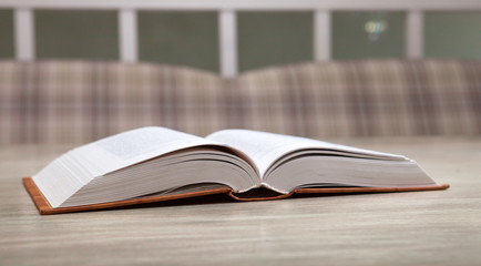 Open book on the table on a blurred background