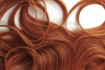 Naklejka premium Curly henna hair as background, texture. One of the popular shades of hair coloring