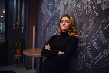 Smiling woman in a good mood with cup of coffee sitting in cafe.
