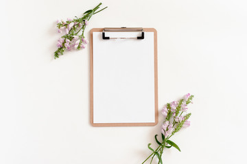 Composition with clipboard mockup and wildflowers on a white background