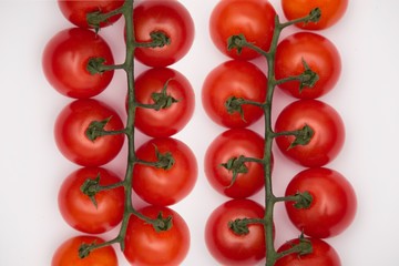 Fresh juicy red cherry tomato bunch closeup isolated on white background. 