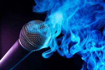 microphone and blue smoke swirls on black background.