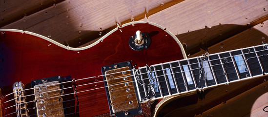 electric guitar behind the glass with water drops . closeup