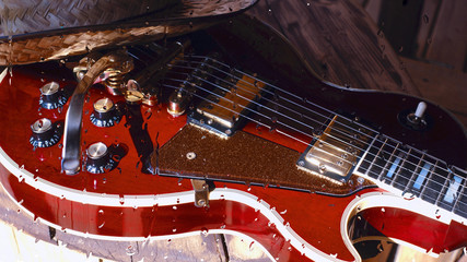 electric guitar behind the glass with water drops . closeup