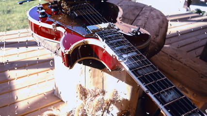 electric guitar behind the glass with water drops . closeup