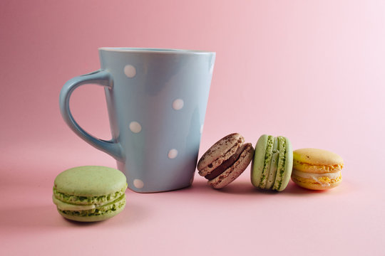  a cup of tea and macaron arranged in a beautiful composition on a pinck background