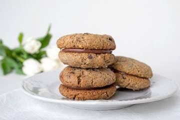 Delicious hazelnut or almond sandwich biscuits with chocolate, ganache and gianduja filling. Baci di dama or Ladys kisses are italian cookies from Piedmont.