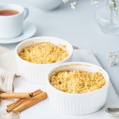 Close up apple crumble with streusel. Side view, close up. Morning breakfast on a light gray table.