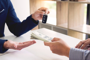 Rental agreement for signing a car insurance policy Document and Form of a Vehicle Sales Agreement, the agent is holding the document and car key.