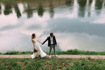 beautiful walk young lovers bride and groom on the river bank