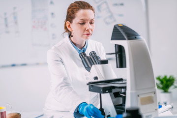 Fototapeta premium Portrait of Young Female Archaeologist with Microscope