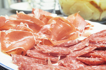 Some iberian ham and acorn-fed salchichon ready for typical Spanish tapeo. Travel and cousin concept with empty copy space for Editor's text.
