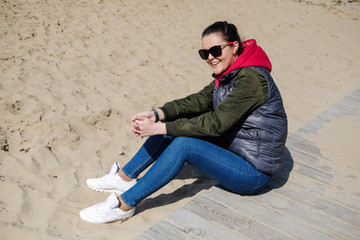 Woman in a red hoodie walking on the beach. Close-up portrait.