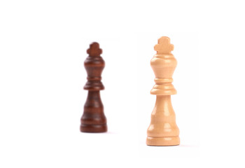 Two chess pieces. Black and white king of wood with blurred background - Isolated on white.