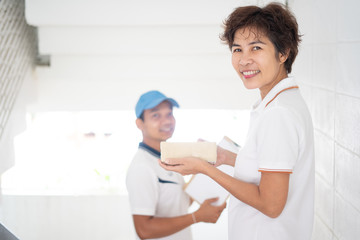  Massenger delivers the parcel box to middle-aged female customers,  the delivery service from the seller to the recipient.