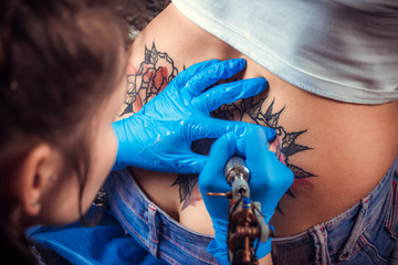 Professional tattooer focused on his work in the salon