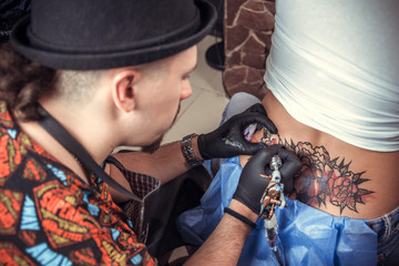Tattoo master working on professional tattoo machine device in tattoo studio