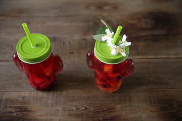 Berries and citrus infused water, tea, cocktail, lemonade, compote. Summer iced cold drink with berries and lemon on a wooden rustic background. With copy space for text. Flat lay. Top view.