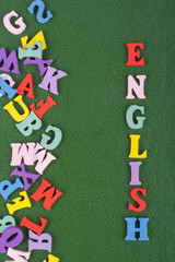 English word on green background composed from colorful abc alphabet block wooden letters, copy space for ad text. Learning english concept.
