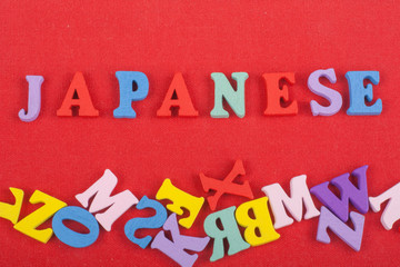 JAPANESE word on red background composed from colorful abc alphabet block wooden letters, copy...