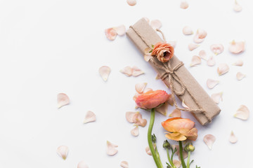 Gift box near flowers on petals