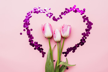Fresh wonderful flowers in heart of confetti