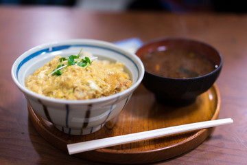 Katsudon served in a large Japanese rice bowl with a pair of chopsticks.