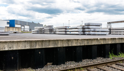 Fototapeta na wymiar Heavy aluminum bars lying on each other on stack in the square of an aluminum smelter.
