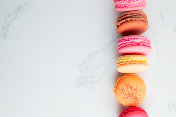 colourful macaroons on a White marble background