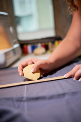 Close-up of female dressmaker lining a sewing cutting-out with a piece of soap in workshop