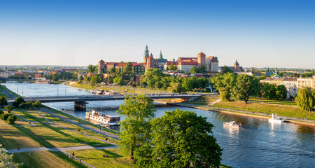 Polen. Luchtpanorama van Krakau met historisch koninklijk Wawel-kasteel en kathedraal, Vistula-rivier met een brug, boten, restaurant aan boord. Promenades en parken langs de rivieroevers. zonsondergang licht