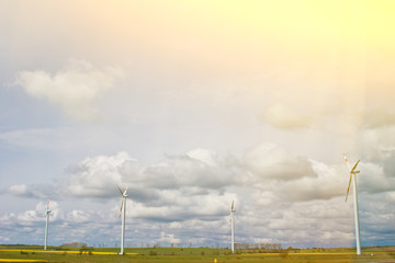 wind power plant in a field against the backdrop of a bright cloudy sky. wind generator close-up. green electricity, alternative energy