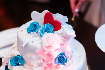 Wedding cake with white and blue roses and hearts
