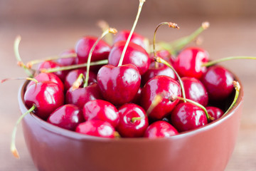 fresh ripe cherries in a plate on a wooden table