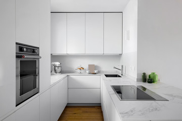 interiors shots of a modern white lacquered kitchen with wooden floor