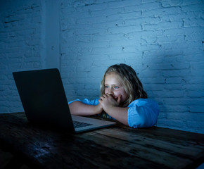 Sad young girl with laptop suffering bullying and harassment online. Cyber bullying victim