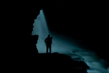 Obraz premium the man silhouette under the waterfall