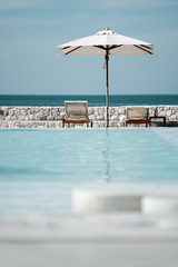 Two Chairs with White Umbrella near the Beach