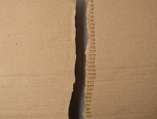 torn in half brown sheet of paper from under the box
