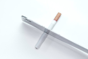 World No Tobacco Day; Use a knife to cut cigarettes isolated on white background. Cigarette destruction concept.