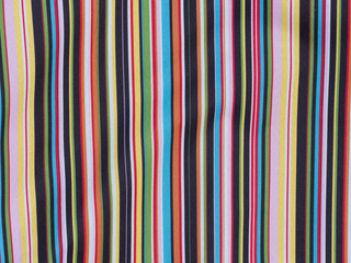 Abstract vibrant multi coloured vertical lines in fabric.